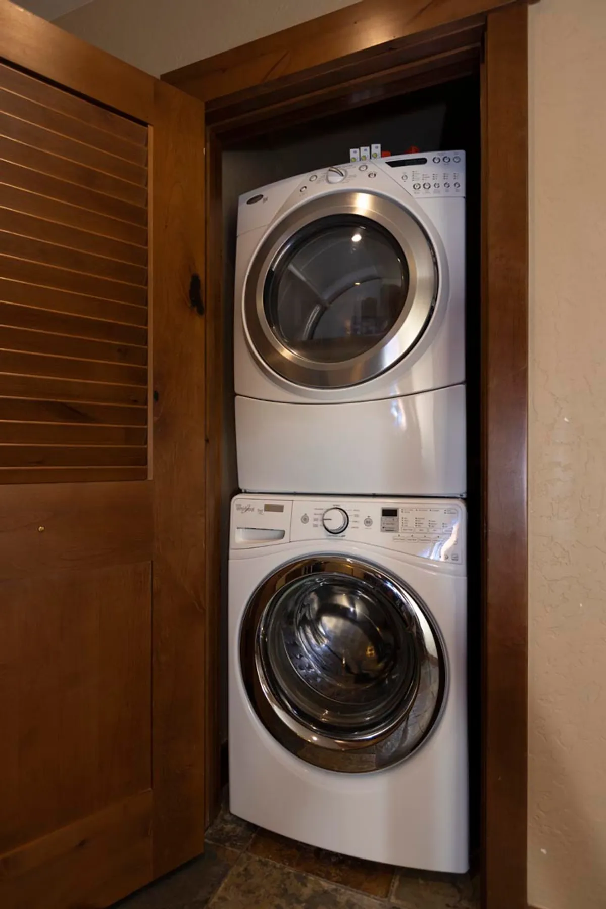 A dedicated laundry area with a stacked washer and dryer neatly tucked between wooden door frames. The space is practical and organized, offering convenience for guests to refresh clothing and gear after outdoor adventures.